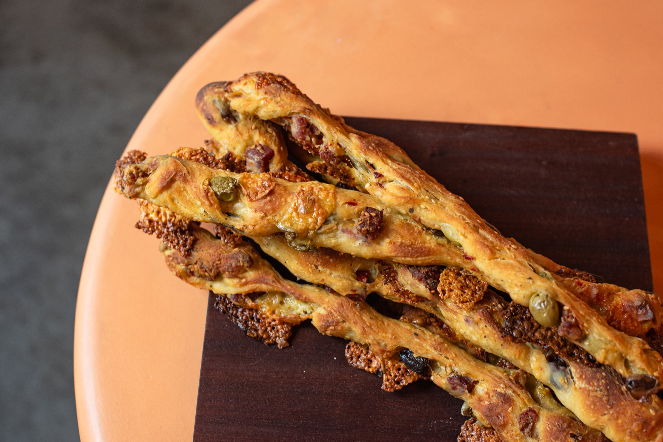 Muffuletta sticks laid on top of a brown cloth 