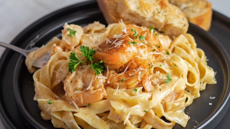 A black plate topped with Cajun shrimp alfredo pasta