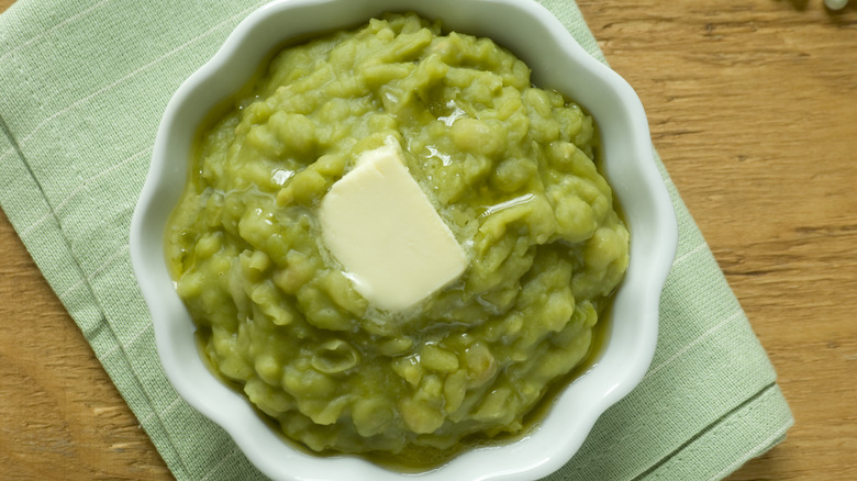 A bowl of mushy peas with butter on top