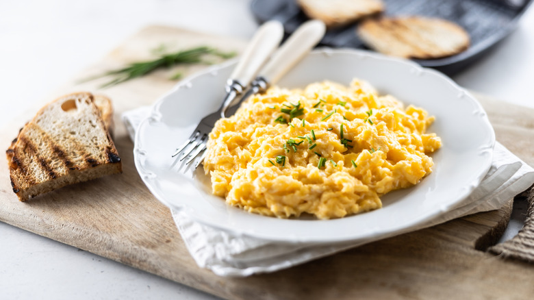 A plate of scrambled eggs with griddle toast